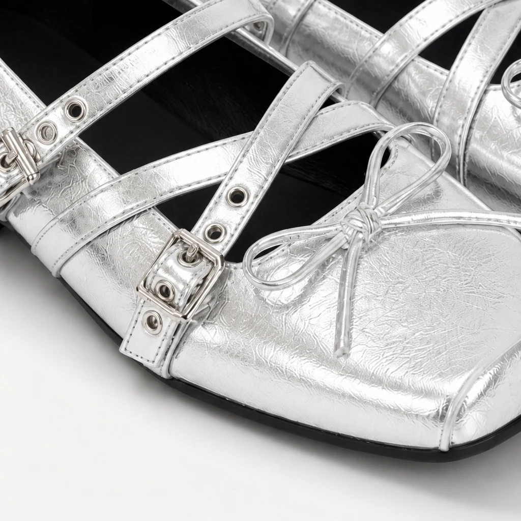 Gros plan sur des chaussures plates Mary Jane argentées montrant une sangle à boucle et des détails de finition