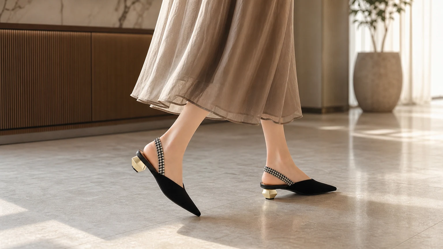 Tacones de oficina negros minimalistas con tira trasera en una escena de atuendo refinado